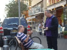 Zev sharing with man on bench