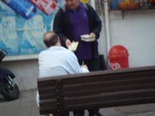 Zev sharing with man on bench